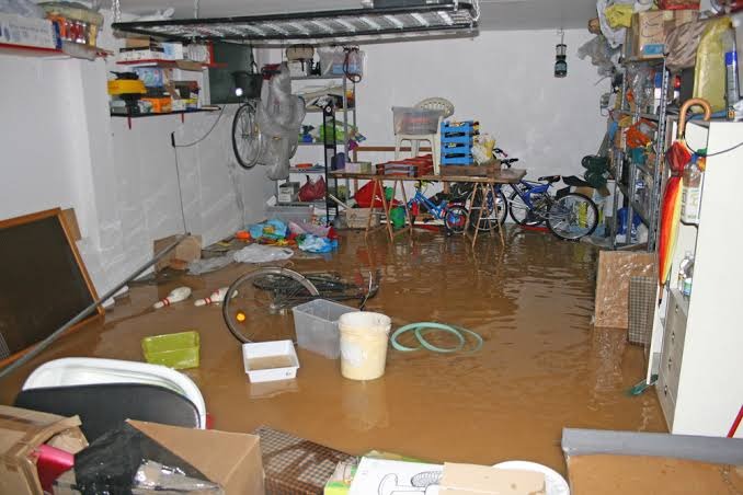 Flooded subterranean garage and residential basement with standing black floodwater requiring rapid containment in Miami